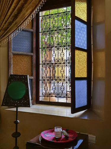 a window in a room with a table and a candle at Palais didi in Meknès