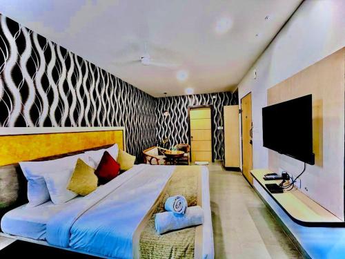 Hotel Lake View Airport zone في حيدر أباد: غرفة نوم بسرير كبير وتلفزيون