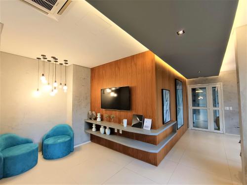 Televisyen dan/atau pusat hiburan di Apartamento 1604 no Bosque com um quarto sala cozinha completa e uma vaga de garagem