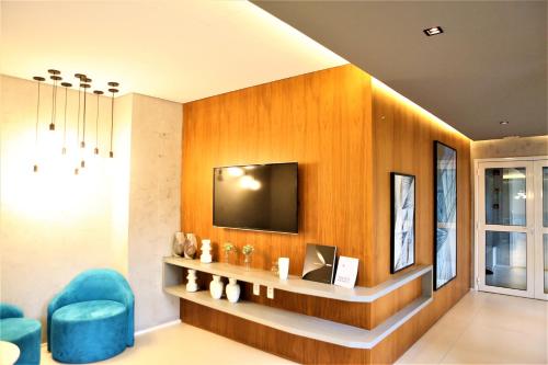 Televisyen dan/atau pusat hiburan di Apartamento 1604 no Bosque com um quarto sala cozinha completa e uma vaga de garagem