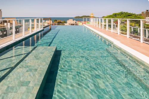 a swimming pool on the roof of a building at Lindos Studios VEC in Bombinhas