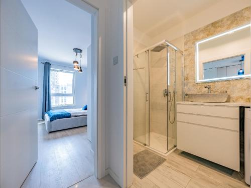a bathroom with a shower and a sink at Hello Apartments Letnica with private parking in Gdańsk