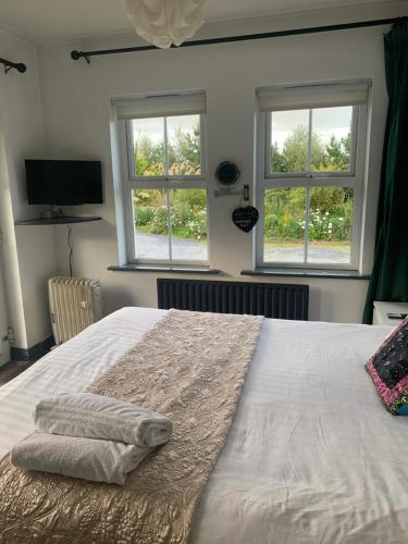 a bedroom with a large bed with two towels on it at Isserkelly House in Clonbur