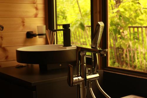 a sink in a bathroom with a window at Inn Martvili in Martvili