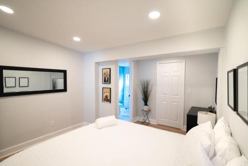 1 dormitorio con cama blanca y puerta azul en Chic & Stylish Fully Renovated Central Location, en Tampa