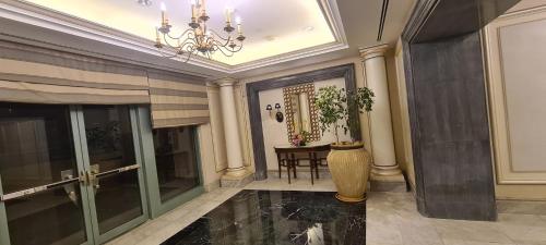 a hallway with a chandelier and a table in a building at LUXURY HOTEL APARTMENT at GRAND PLAZA SAN STEFANO, PRIME LOCATION with access to MEGA MALL and FOUR SEASONS'S RESTAURANTS in Alexandria