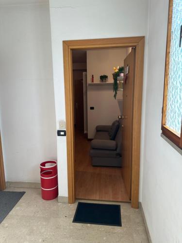 a door leading into a living room with a couch at monolocale in centro in Asiago