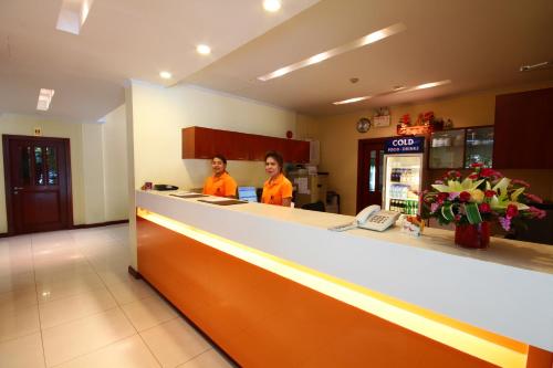 two women in orange shirts standing at a counter in a store at Calypzo Bangkok in Bangkok