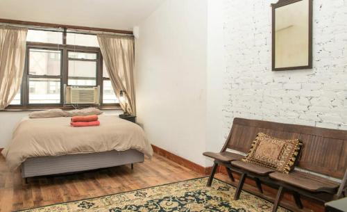 1 dormitorio con cama, banco y pared de ladrillo en Marvelous 3BR in NYC! en Nueva York