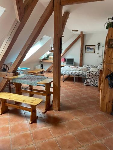 a room with a table and benches in a attic at apartmany mlýn Strmilov in Strmilov