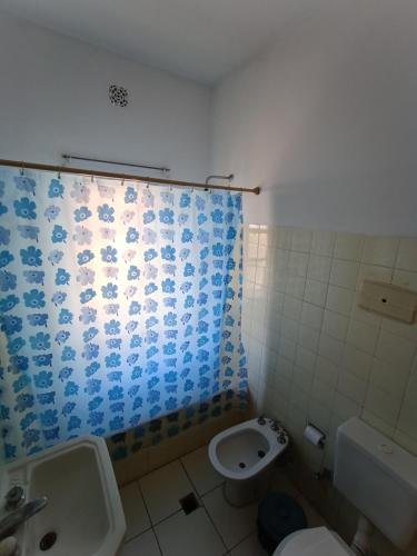 uma casa de banho com um lavatório, um WC e uma cortina de chuveiro. em Casa de Pancho ByB em Mendoza