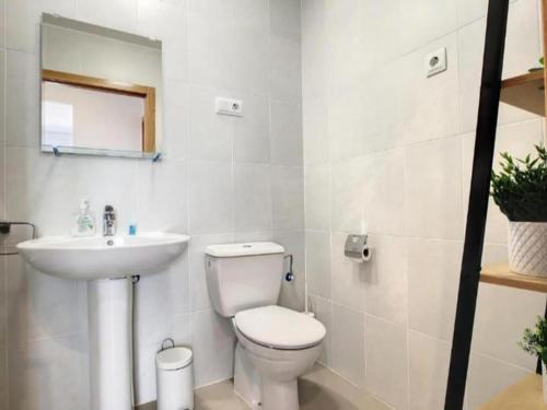 a white bathroom with a toilet and a sink at 2-Bed Penthouse Apartment in Roldán