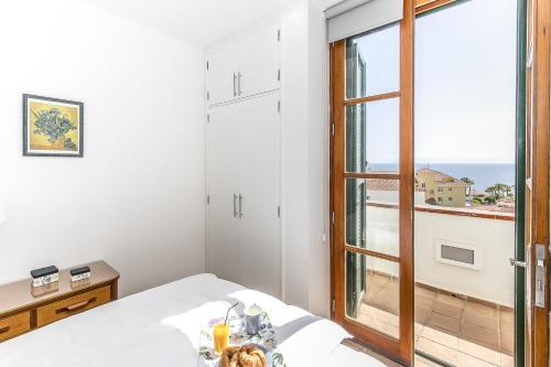 a room with a bed and a view of the ocean at EDEN RENTALS Seaside Getaway in Puerto de Santiago