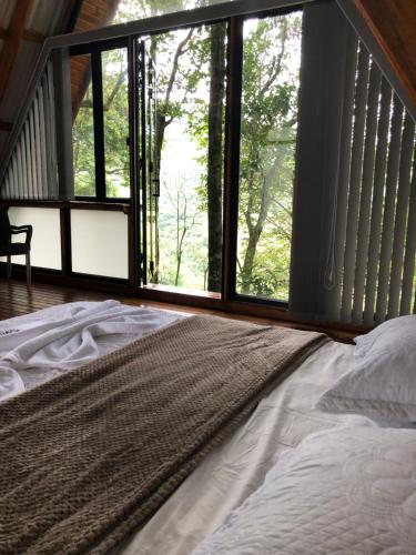 a bedroom with a large bed and a large window at Guayupes Hotel de Aventura in Guamal