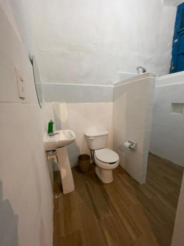 a white bathroom with a toilet and a sink at Bleu Downtown in Campeche