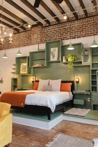 a bedroom with a large bed with green cabinets at Historic Garden Studio, Steps from Pulaski Square in Savannah
