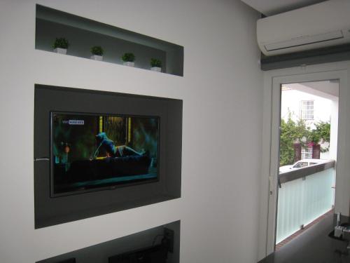 a living room with a tv on a wall at Cascais FEELINGS in Cascais