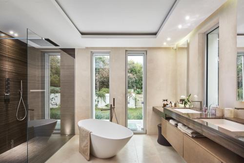 une salle de bain avec une baignoire, un lavabo et une douche dans l'établissement Villa Aquamarine, à Antibes