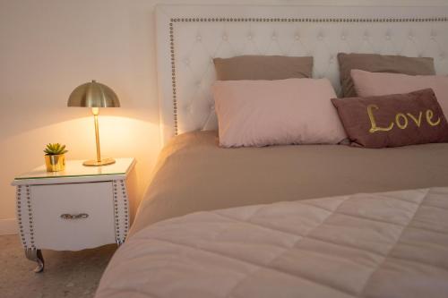 ein Schlafzimmer mit einem Bett mit einem Liebeskissen und einer Lampe in der Unterkunft LES SUITES LOVE 2 SPA VUE MER PISCINe in Marseille
