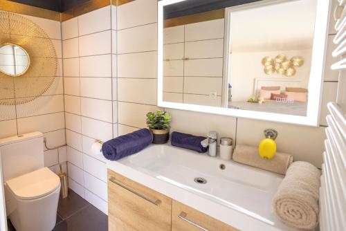 ein Badezimmer mit einem Waschbecken, einem WC und einem Spiegel in der Unterkunft LES SUITES LOVE 2 SPA VUE MER PISCINe in Marseille