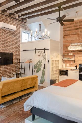a bedroom with a bed and a brick wall at Historic Garden Studio, Steps from Pulaski Square in Savannah