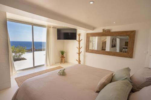a bedroom with a bed and a view of the ocean at LES SUITES LOVE 3 SPA VUE MER PISCINe in Marseille