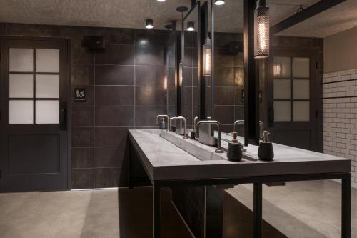 a bathroom with a sink and a large mirror at Moxy San Diego Gaslamp Quarter in San Diego