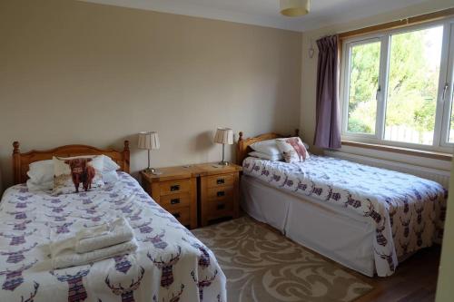 um quarto com 2 camas ao lado de uma janela em Isla Cottage em Blairgowrie