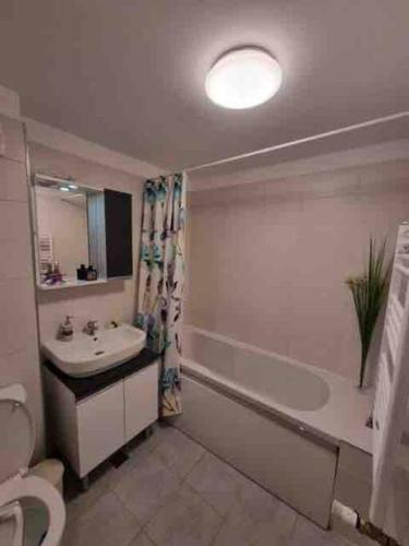 La salle de bains est pourvue d'un lavabo, d'une baignoire et de toilettes. dans l'établissement Chic Studio Pallady, à Bucarest