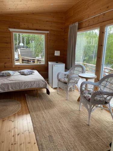 a bedroom with a bed and chairs and a table at Villa Salajärvi in Heinola