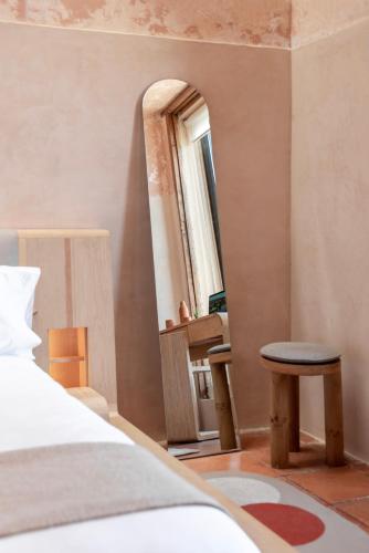 a bedroom with a bed and a mirror and a stool at Jr-Kiyo Estudios in Oaxaca City