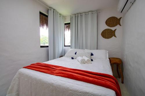 een slaapkamer met een bed met twee handdoeken erop bij Casa Milagres 03 suítes - 300m da Praia, 6 pessoas in Pôrto de Pedras