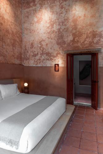 a bedroom with a white bed and a doorway at Jr-Kiyo Estudios in Oaxaca City