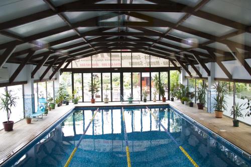 an indoor swimming pool with a large building with windows at Hotel City Ploiesti in Ploieşti