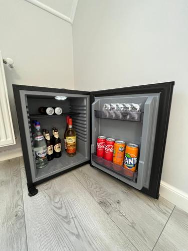 an open refrigerator with drinks and alcohol in it at Glam Studios in Sibiu