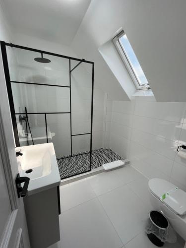 uma casa de banho branca com um chuveiro e um lavatório. em Glam Studios em Sibiu