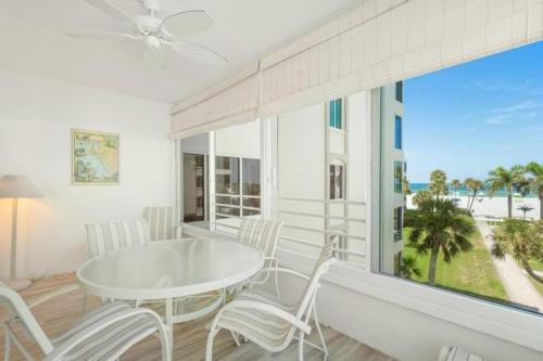 a dining room with a table and chairs and a large window at Island House Beach Resort 14S in Point O'Rocks