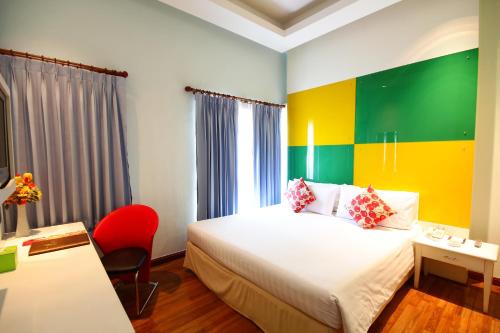 a hotel room with a bed and a red chair at Calypzo Bangkok in Bangkok