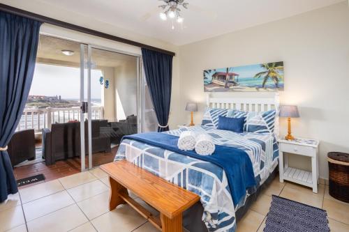 a bedroom with a bed and a view of the ocean at Laguna La Crete 44 in Uvongo Beach