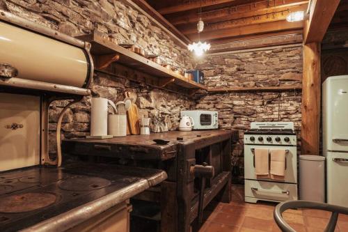 cocina con fogones y pared de piedra en Couples Serenity Cabin Waterfall Lake, en Milford