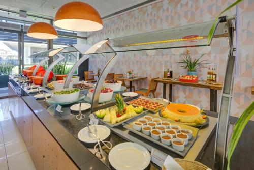 uma linha de buffet com muitos tipos diferentes de alimentos em Quality Hotel São Caetano em São Caetano do Sul