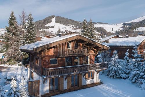 Chalet Planay - Megeve - Mont d'Arbois في ميجيف: كابينة خشبية في الثلج مع الثلج