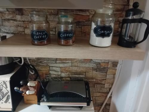 a shelf with jars and a coffee maker on it at Vasiliki Skyros Castle View in Skiros