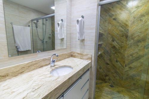 a bathroom with a sink and a shower at Garvey Park Hotel - Apartamento Particular in Brasilia