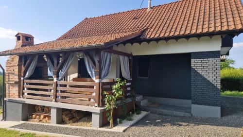 a pavilion with a bench in front of a house at Kuća za odmor Jožić in Novakovec