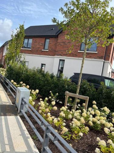 a garden with flowers in front of a house at 3 bed rooms Vip family house in Dublin