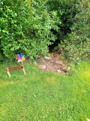 a sign in the grass with a flower on it at Quiet Farm Cottage Enniskillen Fermanagh in Enniskillen