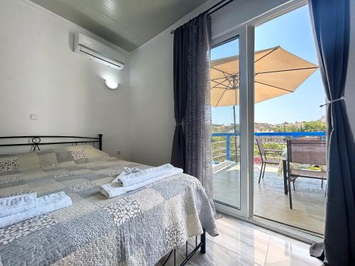 a bedroom with a bed and a balcony with a view at Paradis Studios in Archangelos