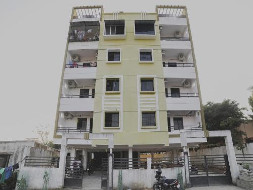 a tall yellow building with balconies on it at Hotel Club Metro in Dhantoli
