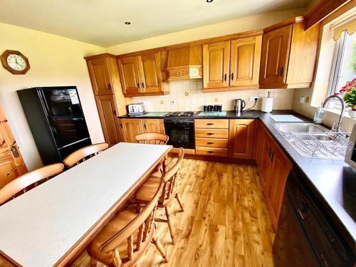a kitchen with wooden cabinets and a white counter top at Quiet Farm Bungalow Enniskillen Fermanagh in Enniskillen